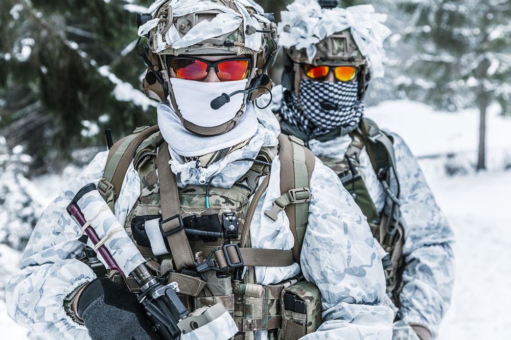 A soldiers wears sunglasses in the Snow.